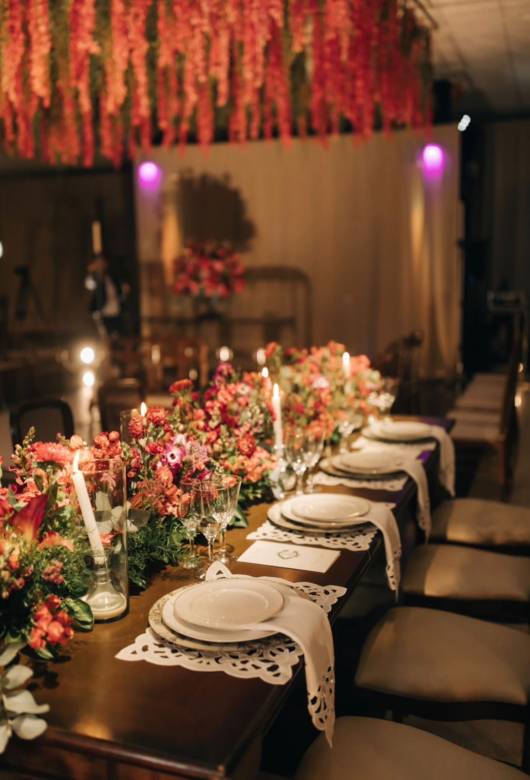 Mesa de banquete de casamento organizada com flores e luzes quentes